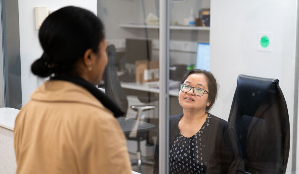 Patient talking to receptionist compressed image