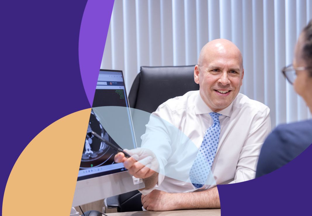 Consultant pointing to image of heart with patient