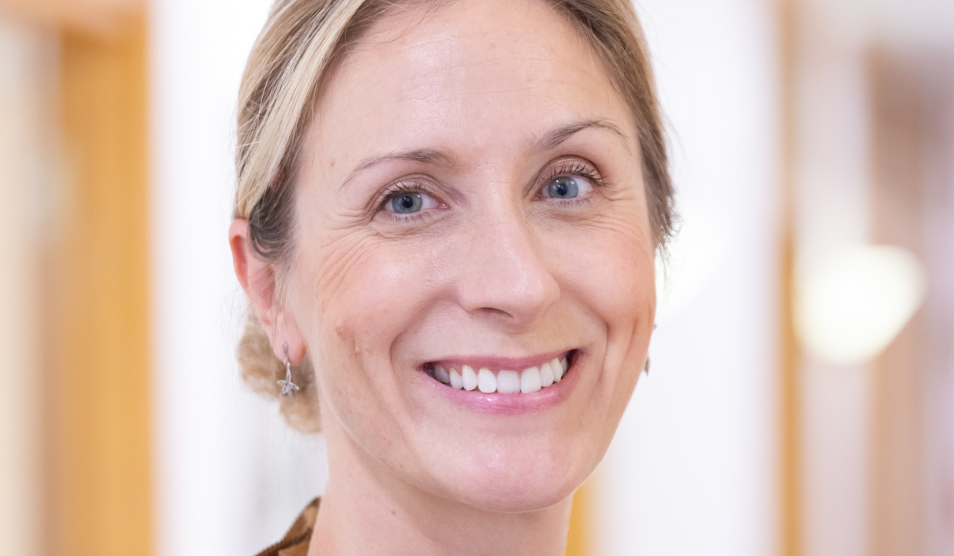 Person looks to the camera and smiles.