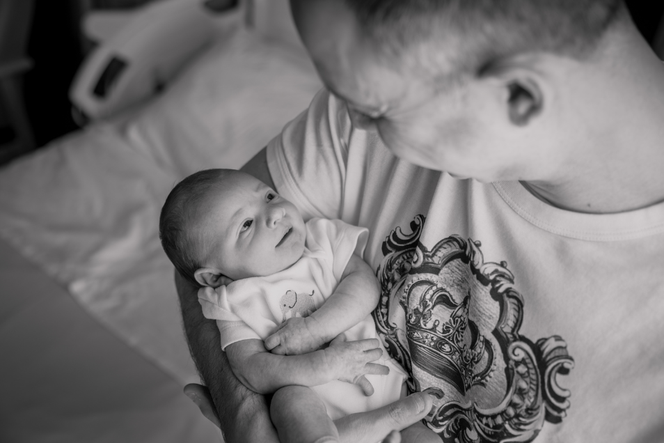 Father holds smiling baby in his arms